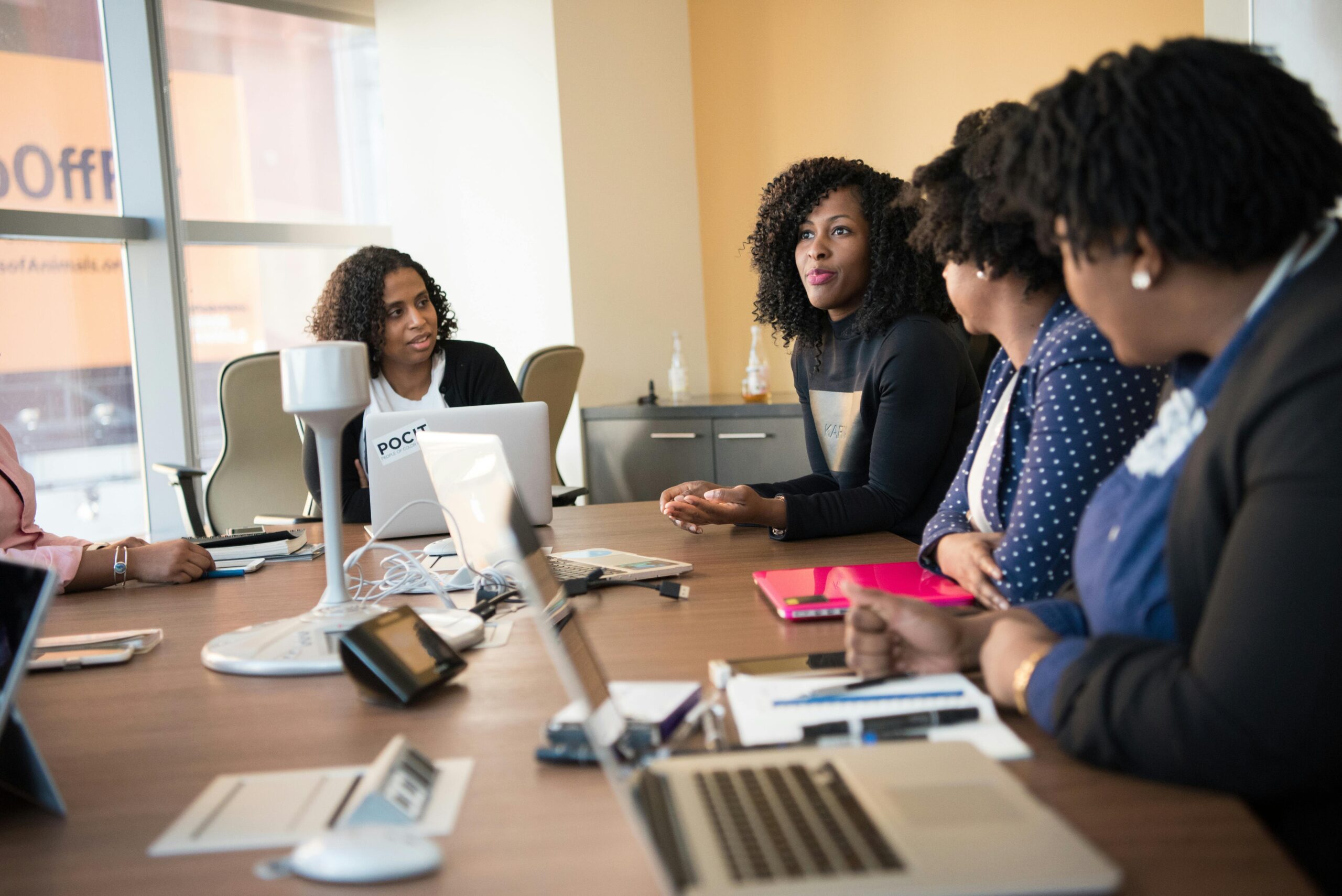 Diverse team of professionals engaging in a collaborative office meeting around a desk.